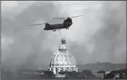  ?? AP/MASSIMO PERCOSSI ?? Smoke billows as a helicopter flies past the dome of St. Peter’s Basilica on its way to extinguish a fire that broke out in the Monte Mario hill area of Rome on Tuesday.