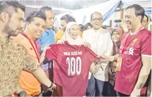  ?? -Gambar Bernama ?? AZIZAH bergambar bersama jersi pada Program Santai Sahur Perlawanan Bola Sepak Champions League Final di Dagang Cahaya Ampang. Turut hadir Anggota Dewan Undangan Negeri (ADUN) Pandan Indah Ir Izham Hashim (tiga, kiri).