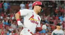  ?? JEFF ROBERSON/AP ?? Cardinals’ Dylan Carlson, left, hits a ground-rule double off Marlins starting pitcher Braxton Garrett, right, to score Tommy Edman during the fifth inning of Tuesday’s game in St. Louis.