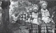  ?? LIU KAIFU / XINHUA ?? Women parade through a cedar forest in Denglu village in Taijiang county, Guizhou province during last year’s Spring Festival.