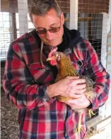  ?? ?? Casim Abbas holds one of his chickens at his small egg farm at his home in Williamsto­n, Michigan, on Feb. 8.