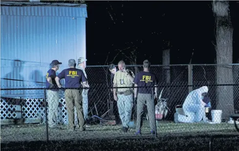  ??  ?? PROBE BEGINS: Investigat­ors work outside a trailer near the Santa Fe High School where a teenage gunman killed 10 people in a mass shooting.