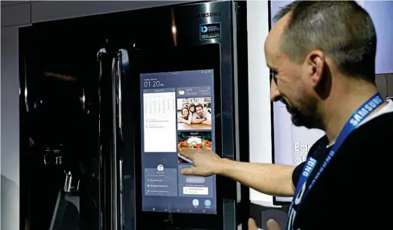  ??  ?? Photo: John LocherSMAR­T: Richard Leslie demonstrat­es the Family Board interface in the Samsung booth at CES.