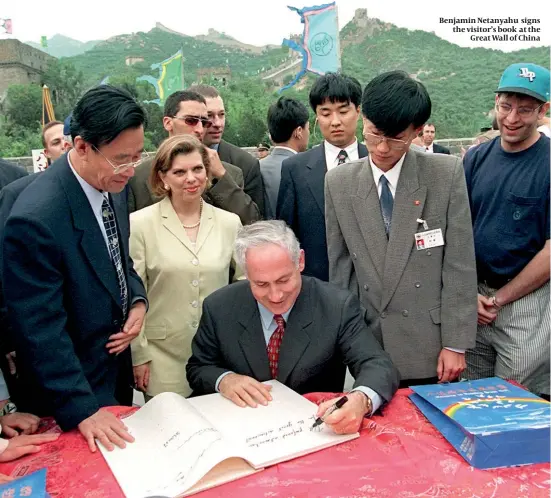  ??  ?? Benjamin Netanyahu signs the visitor’s book at the Great Wall of China