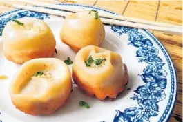  ?? AMY DREW THOMPSON / ORLANDO SENTINEL ?? Shanghai pan fried pork buns — crackin’ crispy below and tender-toothy up top — are best eaten hot and fresh.