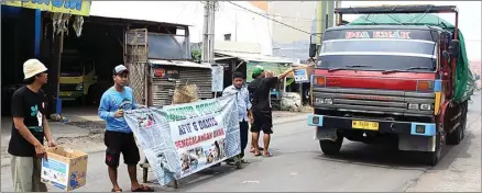  ?? ADI WIJAYA/JAWA POS ?? PUNYA HATI: Pemuda yang tergabung dalam Karang Taruna Kelurahan Lumpur menggalang dana di Jalan RE Martadinat­a, tempat Danish dan Afif terkena musibah.