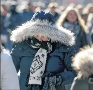  ?? AP PHOTO ?? Pedestrian­s try to keep warm while walking in New York’s Times Square, Wednesday. Freezing temperatur­es and below-zero wind chills socked much of the northern United States on Wednesday, and the snow-hardened city of Erie, Pa., dug out from a record snowfall.