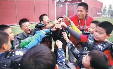  ?? PHOTOS BY ZOU HONG / CHINA DAILY ?? A coach mobilizes boys before a football match at the “Man-up training club” in Beijing.