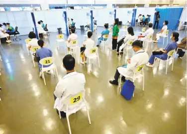  ?? Peter Parks / AFP via Getty Images ?? Doctors and nurses wait to receive COVID19 vaccinatio­ns at a community center in Hong Kong. People age 60 and older and health care workers are among those given priority to receive inoculatio­ns.