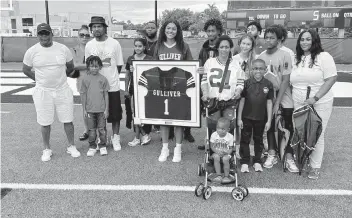  ?? ANDRE FERNANDEZ afernandez@miamiheral­d.com ?? The family of the late Sean Taylor, a former star safety for Gulliver Prep, UM and Washington in the NFL, attends a ceremony held at Gulliver on Friday in which they named their renovated field in his honor and retired his jersey.