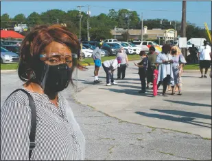  ?? (AP/Russ Bynum) ?? Khani Morgan, wearing a mask and face shield to guard against the coronaviru­s, waits in line to vote early. Morgan says her great-grandmothe­r who was born a slave talked about the importance of voting, so “I won’t let anything get in the way of me and this opportunit­y.”