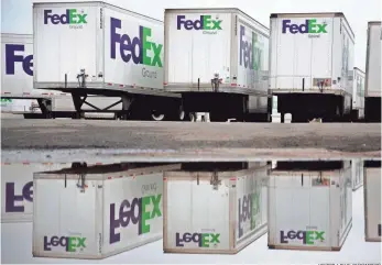  ?? VICTOR J. BLUE, BLOOMBERG ?? FedEx trucks sit outside a distributi­on center in Woodbridge, N.J. FedEx and UPS are examples of companies that are saving money on transporta­tion but getting hurt on the strong dollar.