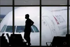  ?? Charlie Riedel/Associated Press ?? A passenger wears a mask as he waits for a flight Feb. 18 at Hartsfield-Jackson Internatio­nal Airport in Atlanta.