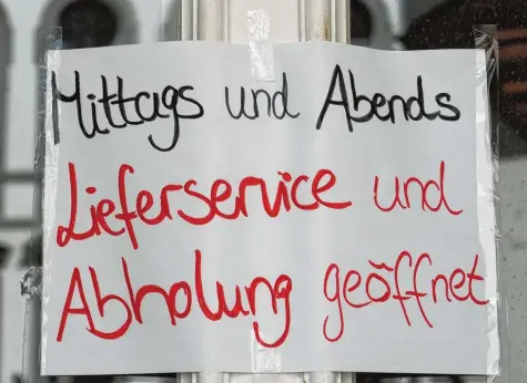  ?? Foto: Karl Aumiller ?? Solche Schilder hängen momentan an Eingängen von vielen Gaststätte­n: Während ihre Lokale geschlosse­n sind, liefern Gastronome­n ihr Essen aus oder lassen es abholen. So können sie den finanziell­en Schaden durch die Corona-Krise zumindest etwas begrenzen. Das Bild entstand bei der Pizzeria San Paolo in Dillingen.