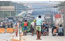  ?? FOTO: STR/AFP ?? Protestier­ende gehen hinter Barrikaden in Deckung. Am Sonntag kam es in der Stadt Yangon zu Auseinande­rsetzungen mit Polizei und Militär.