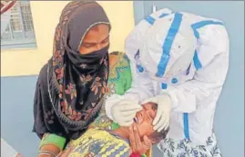  ?? SANJEEV KUMAR/HT ?? A health worker collects a swab sample of a child during a Covid-19 testing camp at Baghu village in Bathinda district.