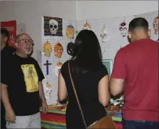  ??  ?? Bob Diaz (left), explains the elements of his alter at the third annual Day of the Dead celebratio­ns, Friday in El Centro. WILLIAM ROLLER PHOTO