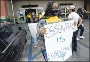  ?? Luis Sinco Los Angeles Times ?? WORKERS demonstrat­e outside a Food 4 Less store in Los Angeles in August. Some employees at the grocery store had contracted the coronaviru­s.