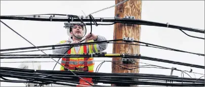  ?? AP PHOTO ?? A utility worker attaches wires on a power pole Tuesday in Watertown, Mass. Utilities are racing to restore power to tens of thousands of customers in the Northeast still without electricit­y after last week’s storm as another nor’easter threatens the...