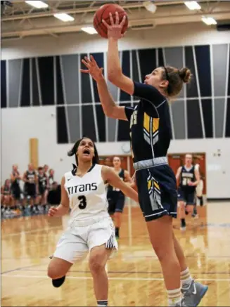  ?? RANDY MEYERS — THE MORNING JOURNAL ?? Izzy Geraci scores with the left hand over Normajanae Bohannon of Lorain during the first quarter. Geraci scored her 1,000th career point during the game.