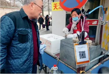  ??  ?? Les stands de rue adoptent aussi le code-barres de paiement via WeChat.