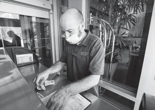  ?? Photos by Yi-Chin Lee / Staff photograph­er ?? Valet supervisor Arturo Gomez organizes tabs at Embassy Suites. Few of the rooms the hotel had reserved for OTC have actually been purchased.