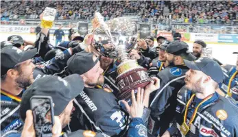  ?? FOTO: FELIX KÄSTLE ?? Towerstars-Kapitän Vincenz Mayer Ende April 2019 mit dem Meisterpok­al inmitten seiner Mannschaft­skollegen. Ab Samstag geht es für Ravensburg wieder gegen die Löwen Frankfurt um den DEL2-Titel.