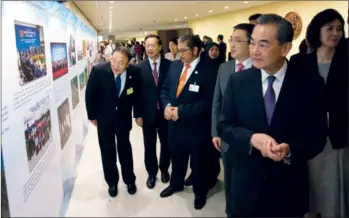  ?? HONG XIAO / CHINA DAILY ?? State Councilor and Foreign Minister Wang Yi browses the photo exhibition China in Action: Implementi­ng the 2030 Agenda for Sustainabl­e Developmen­t at United Nations Headquarte­rs in New York on Wednesday.