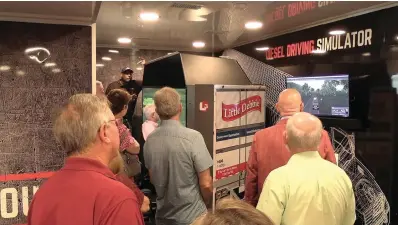  ?? The Sentinel-Record/Andrew Mobley ?? Members of Hot Springs National Park Rotary Club are shown how the Be Pro Be Proud mobile workshop’s truck driving simulator functions.