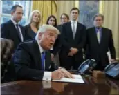  ?? THE ASSOCIATED PRESS ?? President Donald Trump signs an executive order on the Keystone XL pipeline Tuesday in the Oval Office of the White House in Washington.