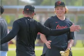  ?? KARL MERTON FERRON/BALTIMORE SUN ?? Orioles infield coach Tony Mansolino said Jackson Holliday, being welcomed by a teammate during a spring training workout Feb, 21, has an innate ability to slow the game down in a way that’s exceptiona­lly rare for players his age.