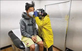  ?? HYOSUB SHIN / HYOSUB.SHIN@AJC.COM ?? AJC visual journalist Hyosub Shin’s son, Jay, is examined recently after falling ill with flu-like symptoms. Shin, self-quarantini­ng since then, misses covering this “historic time.”