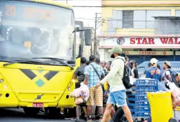  ?? KENYON HEMANS/PHOTOGRAPH­ER ?? Commuters jostle for space as they prepare to board a Jamaica Urban Transit Company bus at the South Parade terminus in downtown Kingston on Wednesday.