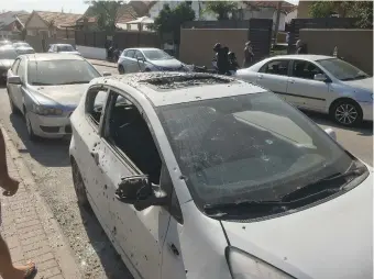  ?? (TPS; Abed Rahim Khatib/Flash90) ?? DAMAGE TO CARS in Sderot caused by a rocket fired by Palestinia­n Islamic Jihad from Gaza on Friday. Right: Gazans inspect positions of Izz ad-Din al-Qassam Brigades in Khan Yunis that were destroyed by IAF fighter jets on Friday night.