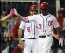  ?? MARK TENALLY — THE ASSOCIATED PRESS ?? Washington’s Michael Taylor, right, and Anthony Rendon, center, celebrate Taylor’s two-run home run in the eighth inning of the second game of a doublehead­er against the Phillies Sunday in Washington.