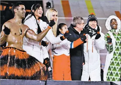  ?? KIRSTY WIGGLESWOR­TH/AP ?? “Shirtless Tongan” Pita Taufatofua; Lindsey Vonn, third from left; and IOC President Thomas Bach (dark coat) at the closing ceremony.