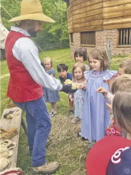  ?? BY NIKKI BRADY ?? WCDS classmates look on as Lucy Whitson touches wool, one of the important resources colonists were able to use from sheep.