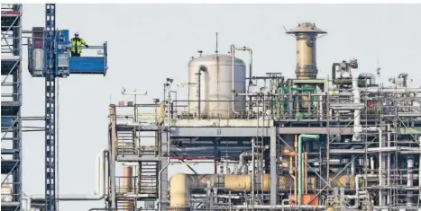  ?? FOTO: DPA ?? Ein Arbeiter fährt auf dem Werksgelän­de des Chemiekonz­erns BASF in einem Aufzug. Die Branche hat im Land großen Einfluss auf die Wirtschaft­sleistung.