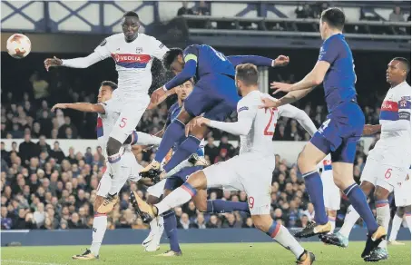  ??  ?? Everton defender Ashley Williams (blue) powers home his header to haul the Toffees level briefly against Lyon last night.