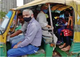  ?? — PTI ?? An autoricksh­aw packed with passengers plies near Kaushambi bus terminal amid ongoing Covid-19 pandemic in Ghaziabad on Friday.