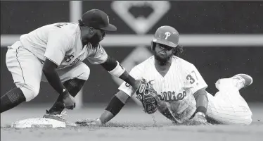  ?? YONG KIM/TRIBUNE NEWS SERVICE ?? The Philadelph­ia Phillies' Odubel Herrera, right, is tagged out trying stretch a single into a double against Pittsburgh Pirates second baseman Josh Harrison on Thursday in Philadelph­ia.