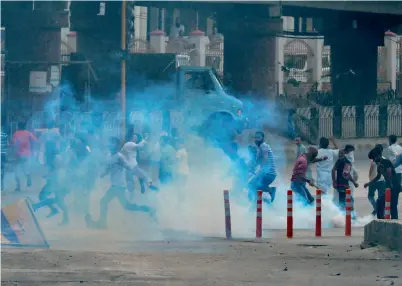  ?? AFP ?? Kashmiri protesters run away after police fired tear gas to stop the crowd from marching towards Srinagar’s downtown Lal Chowk area on Tuesday. —