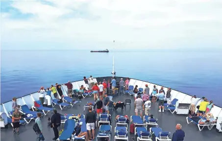  ??  ?? Passengers can walk on the deck and sit in chairs while taking in the Lake Michigan view from the SS Badger. The older boat is more like a ship.