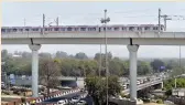  ??  ?? Metro Pink Line moves across Majlis Park- Durgabai Deshmukh South Campus Metro section in New Delhi.