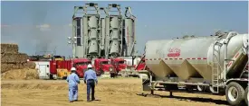  ?? (Bloomberg) ?? Employees walk towards Halliburto­n Co ‘sand castles’ at an Anadarko Petroleum Corp hydraulic fracking site in Colorado, US