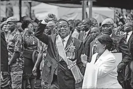  ?? CURTIS/THE ASSOCIATED PRESS] [BEN ?? Zimbabwe’s new president, Emmerson Mnangagwa, center, and his wife, Auxillia, depart after his inaugurati­on Friday in the capital, Harare.