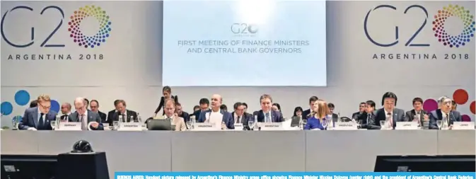  ?? — AFP ?? BUENOS AIRES: Handout picture released by Argentina’s Finance Ministry press office showing Finance Minister Nicolas Dujovne (center right) and the president of Argentina’s Central Bank Federico Sturzenegg­er (center left), during the opening of the G20...