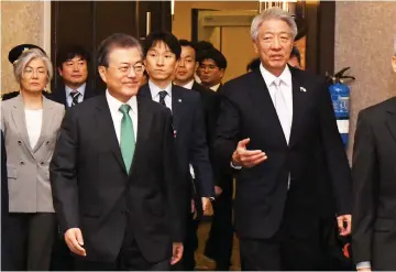  ??  ?? Moon (left) with Singapore Deputy Prime Minister and Coordinati­ng Minister for National Security, Teo Chee Hean (right) arrive at the ISEAS-Yusof Ishak Institute 42nd Singapore lecture during a three-day state visit in Singapore. — AFP photo