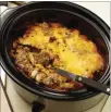  ?? MICHAEL TERCHA/ CHICAGO TRIBUNE/TNS ?? The double-decker cheeseburg­er casserole layers the expected elements (ground beef, tomato, cheese, pickle relish, etc.) in an unexpected slow cooker dish.