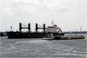  ?? Jon Shapley / Staff photograph­er ?? A towboat navigates past a ship in the Houston Ship Channel. One barge can carry the same liquid cargo as 144 semitraile­rs or 46 train cars.